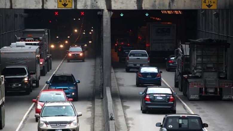 cars driving into and out of tunnel