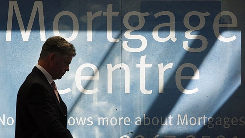 A man looks at an information board in a bank mortgage centre