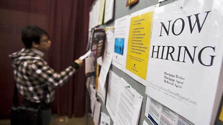 A man looks at a job board posted at a job fair in Toronto, April 1, 2009. 