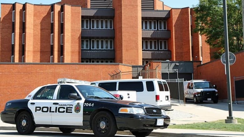 A police car in front of a jail.