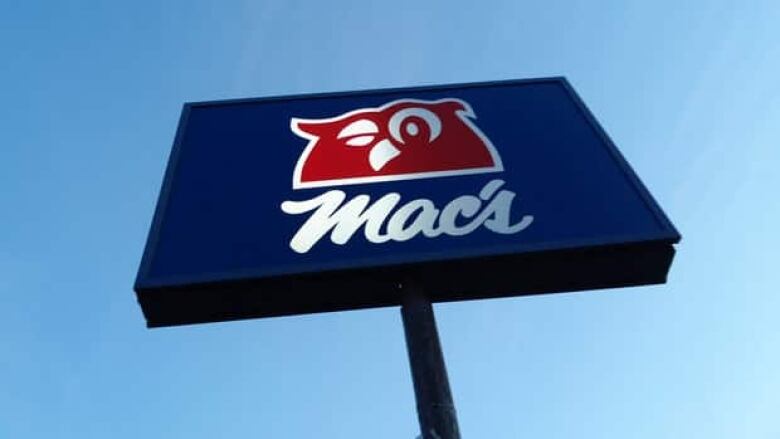 A sign with a blue background and red winking owl, which reads Mac's.