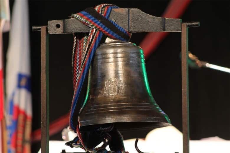 An old bell wrapped with a colourful ribbon.