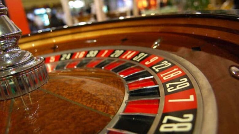 A roulette table with black and red numbered squares is pictured. 