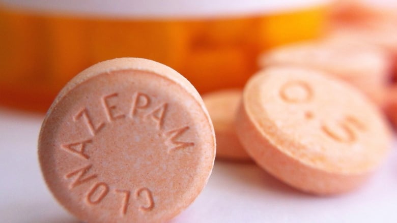 Orange pills marked 'Clonazepam' and '0.5', meant to represent generic drugs.