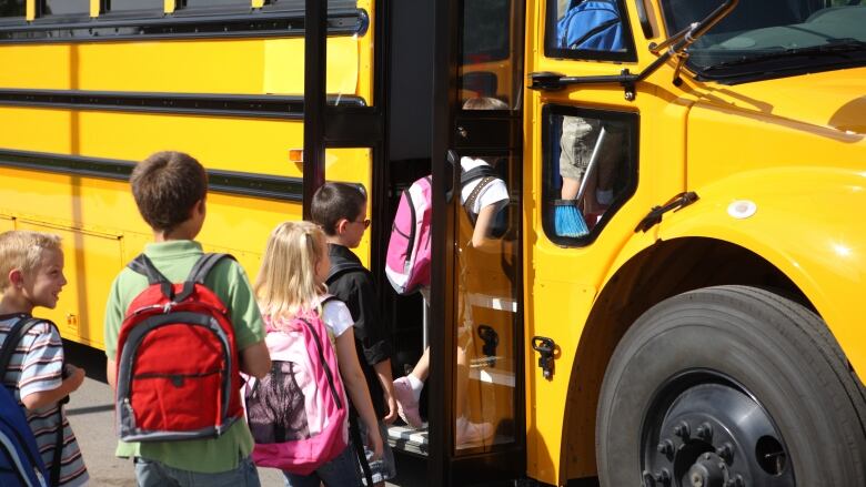 Kids getting on school bus.