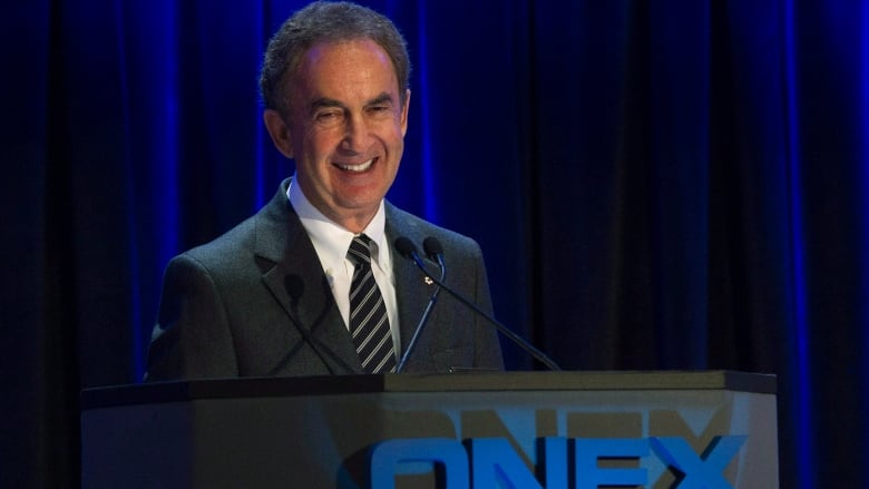 Gerry Schwartz is shown at the AGM of Onex standing at a podium.