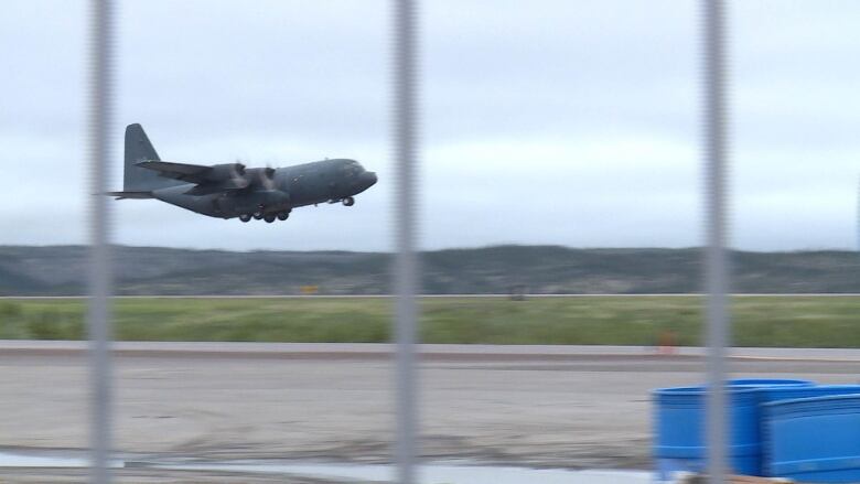 A Hercules C-130 aircraft is seen taking off from an airport runway.