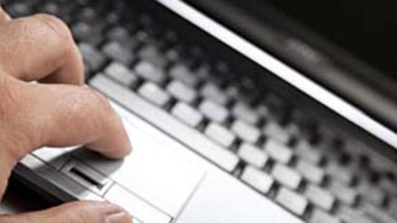 A hand types on a computer keyboard. 