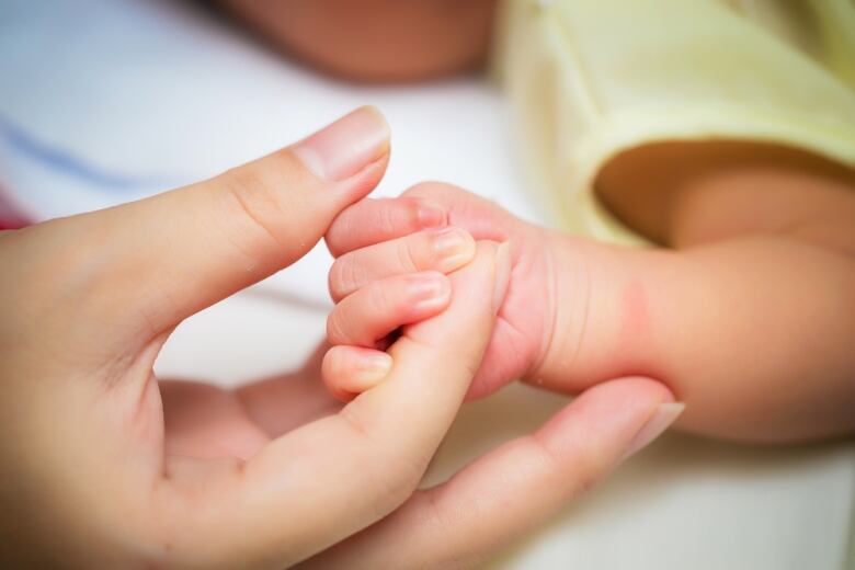 A baby's hand is pictured.