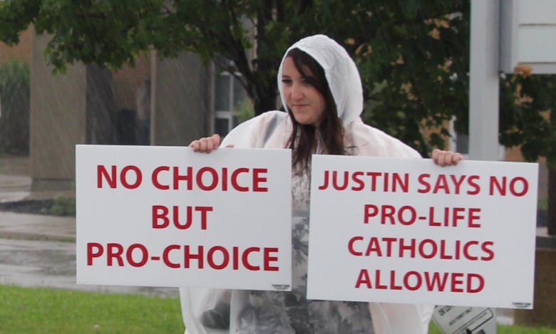 Alissa Golob of the Campaign Life Coalition stands outside cole secondaire catholique Pre-Ren-de-Galine in Cambridge, Ont.