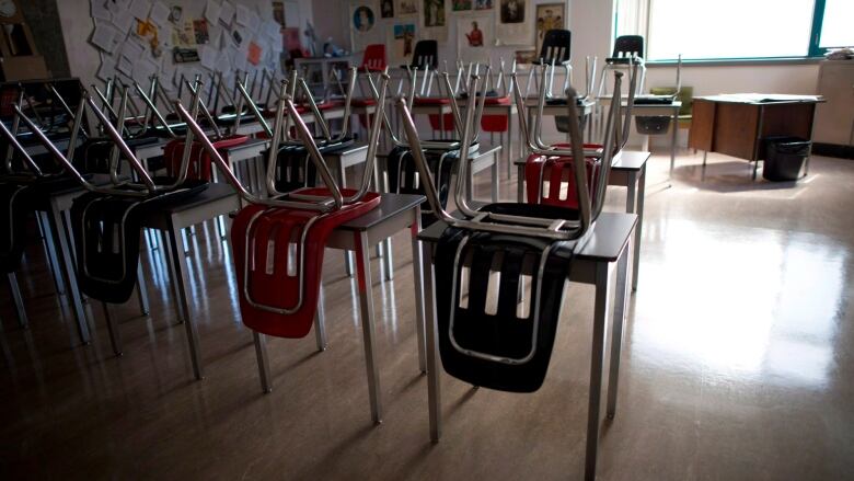 Rows of desks and chairs in an otherwise empty classroom.