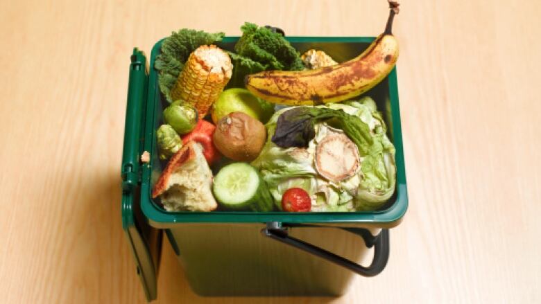 An open green bin filled with food. 