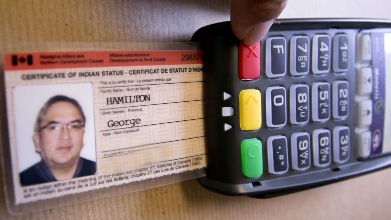 A First Nations status card inserted into a debit machine.