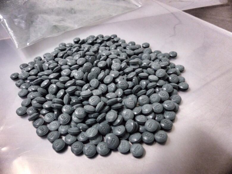 A pile of dark grey pills on a table