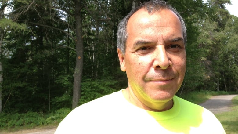 A middle-aged man wearing a white shirt.