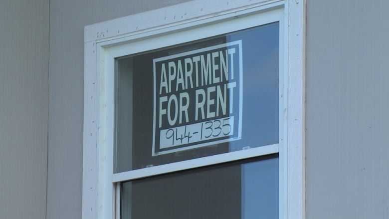 For rent sign taped to the window of a house.