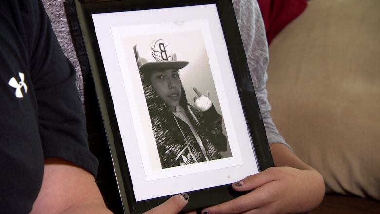 A framed black and white photo shows a young boy in a ball cap and hoodie.