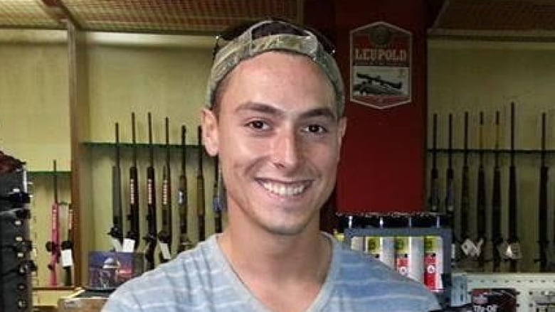 Portrait of man holding a gun in a gun shop.