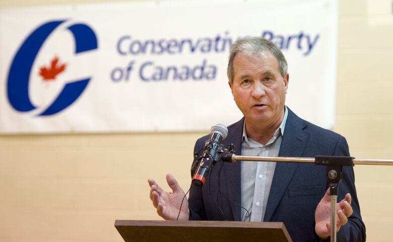 A man speaks at a podium.