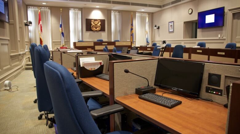 a computer and office chair at a desk in city council chambers