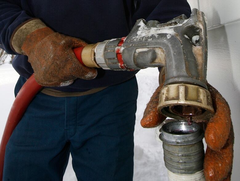 FILE-In this Jan. 2, 2008 file photo, Wayne Holland of the Suburban Propane company delivers oil in Barre, Vt. More than a decade ago, Vermont began taxing electric bills to pay for a statewide energy efficiency program that's widely regarded as a big success. Now, there's a push to apply the same principle to home heating. A recent report from a task force assembled by the Department of Public Service estimated that to raise $30 million for expanded weatherization, programs would mean a tax on oil of about 12 cents per gallon. But advocates say the savings for consumers could be much larger.