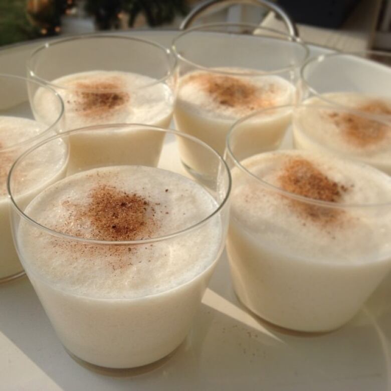 A tray of glasses with eggnog in them.