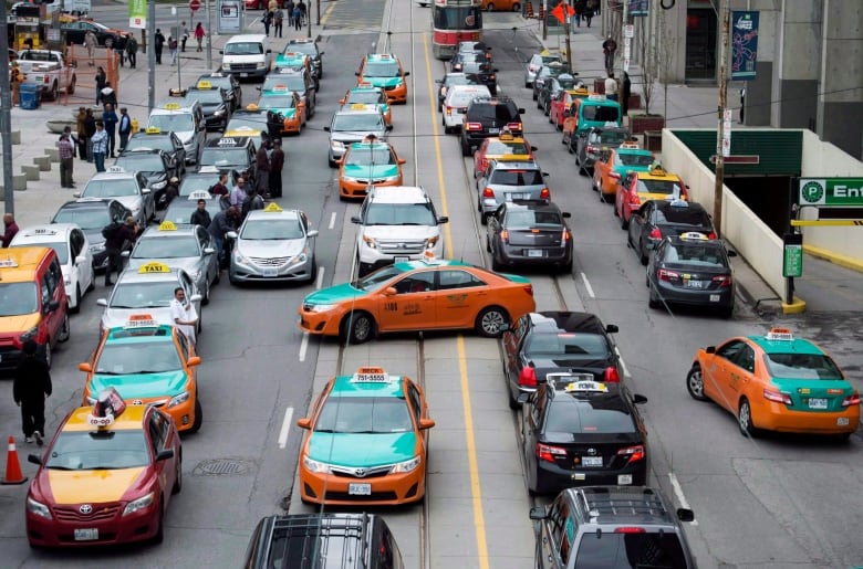 A congested city street full of taxis and other vehicles.