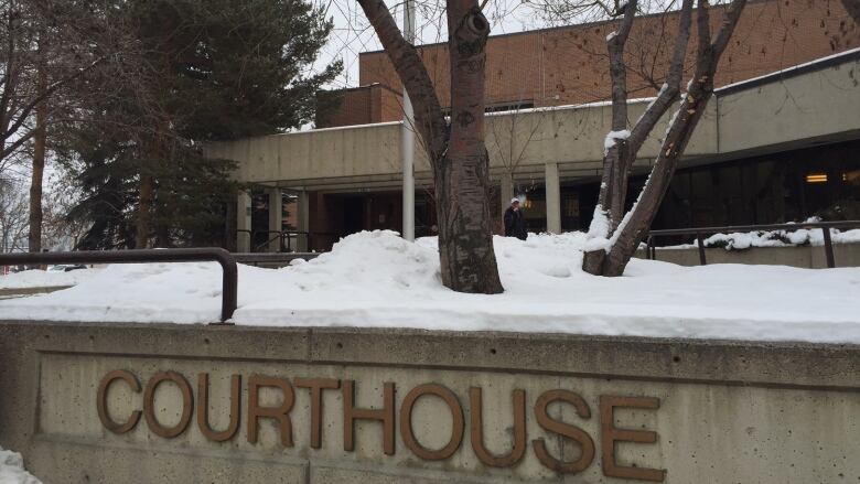 a courthouse sign in front of a building with snow on the ground