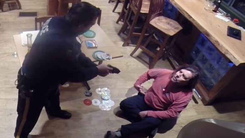 A screen capture of RCMP Cst. Mark Thomaes and Bruce Webb from security footage in the Purple Leprechaun Roadhouse in Bayport, NS from Feb. 28, 2016.