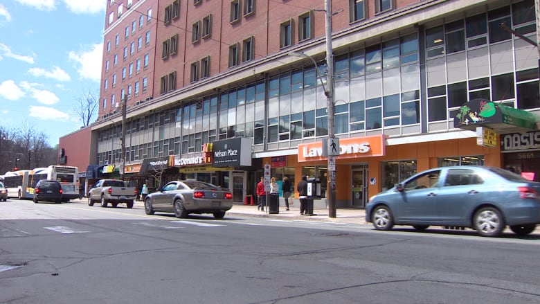 Cars drive past businesses and restaurants 