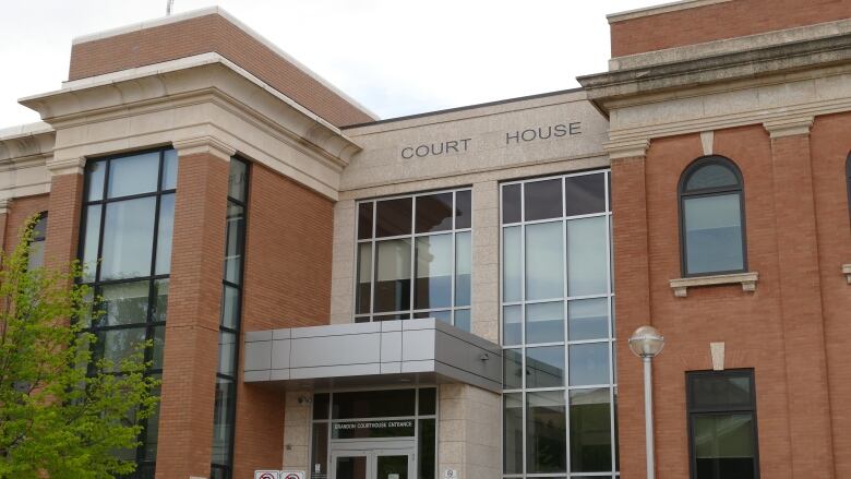 The exterior of a brick building with the words 'court house' written above the doors.