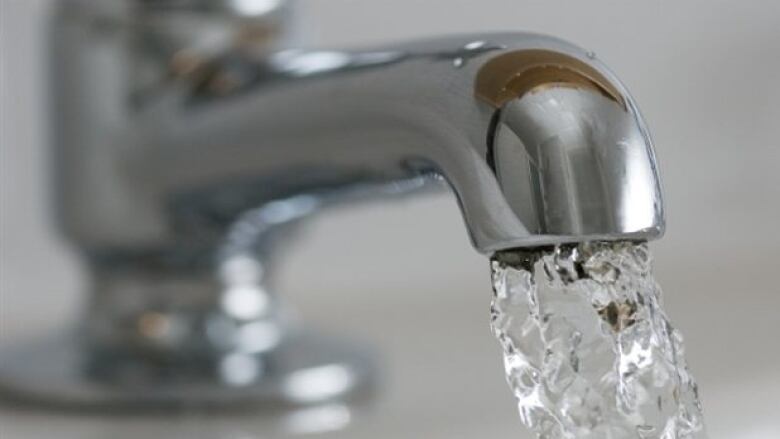 A close-up photo of a water tap with water flowing out of it.