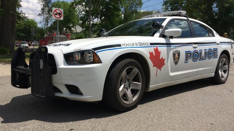 A photo take on an angle of a white police cruiser with a Windsor Police Service logo on the side. 