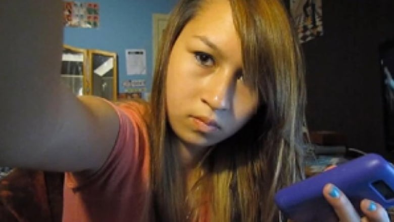 Amanda Todd holding a cell phone.