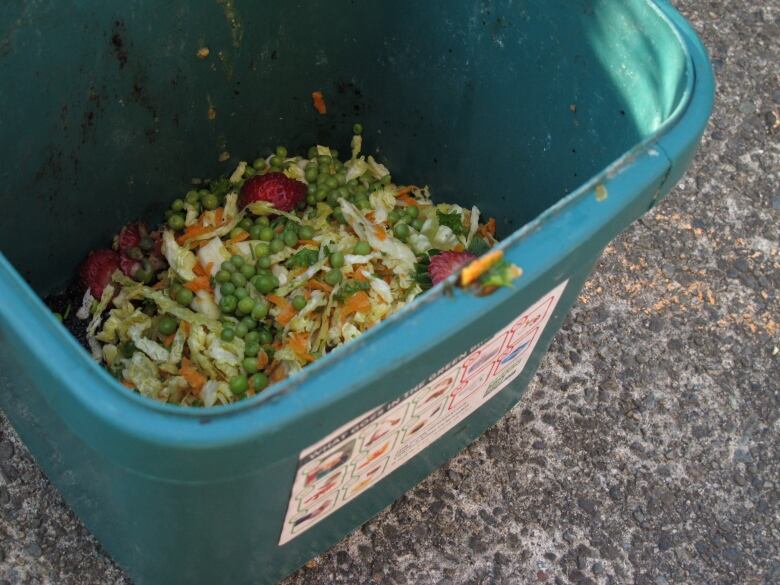 Green bin with food scraps inside. 