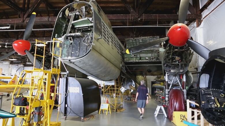 A Second World War Lancaster Bomber plane being restored in an airplane hangar. 