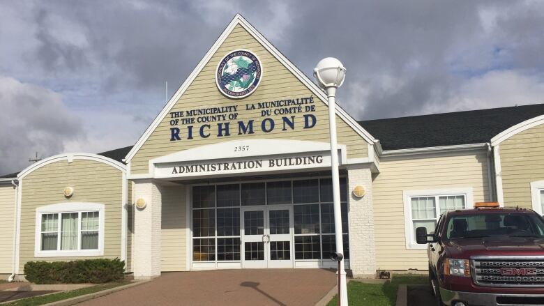 A beige municipal building. The lettering on the front reads THE MUNICIPALITY OF THE COUNTY OF RICHMOND in French and English. Underneath, lettering reads: Administration Building.