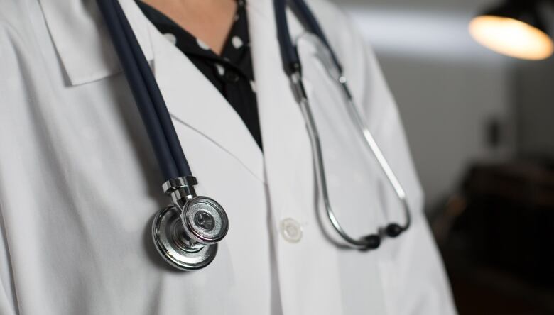 A doctor wearing a white coat and stethoscope. 