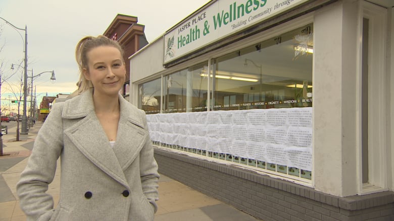 Woman standing in front of health and wellness clinic.