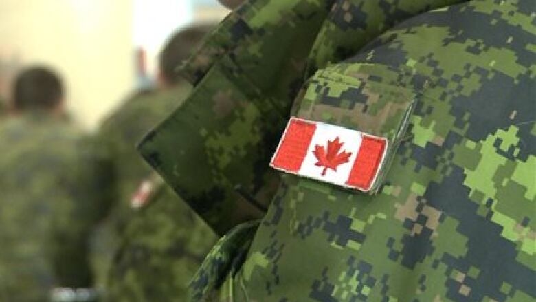 A Canadian flag patch sewn onto green army fatigues.