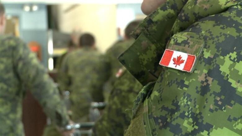 A Canadian flag patch sewn onto green army fatigues.