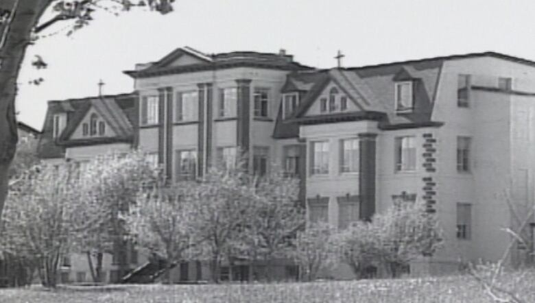 An old school building is pictured in a black-and-white-photo.