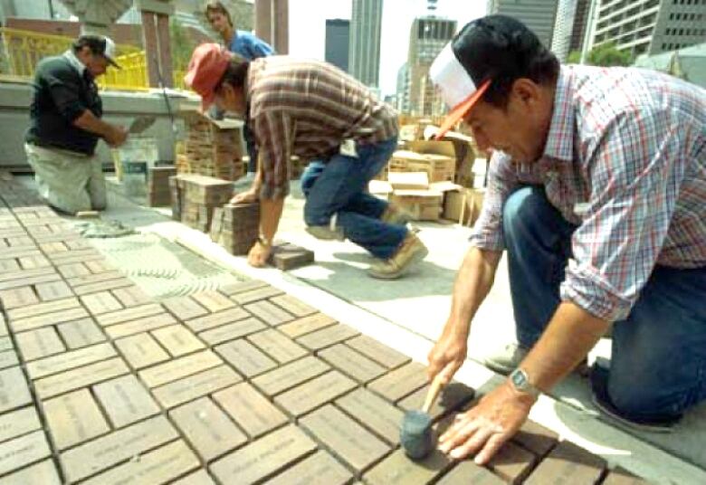 A group of people laying bricks