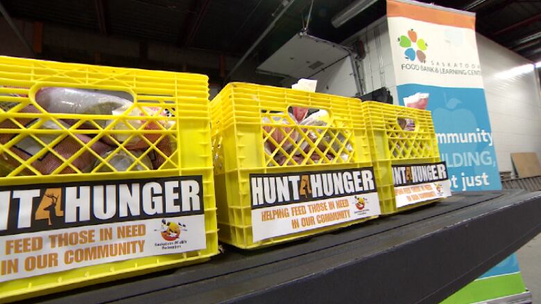 Crates on a shelf hold food.