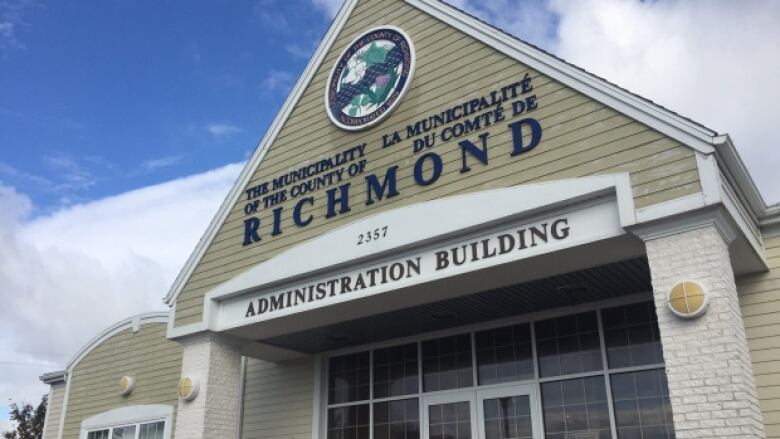 The triangular front of a white-and-tan coloured building contains the words The Municipality of the County of Richmond and Administration Building.