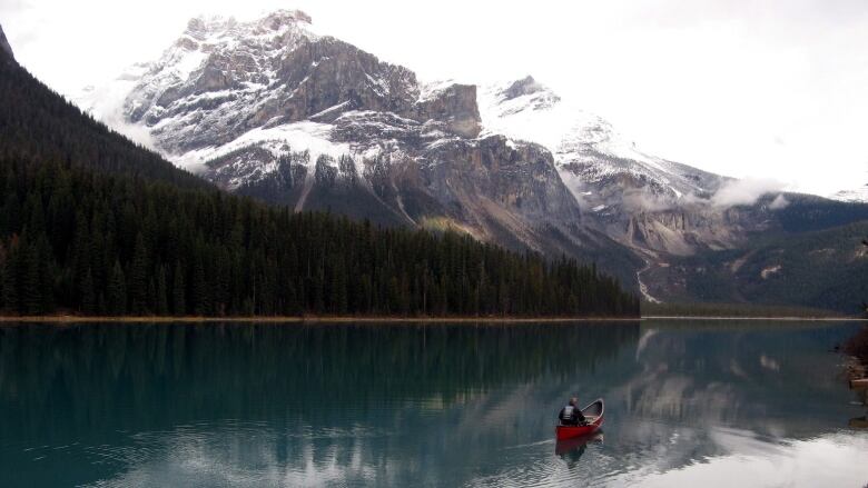 A canoe on a lake with mountains in the background.