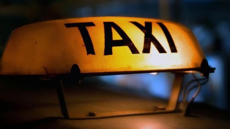 A closeup of a lit rooftop taxi sign.