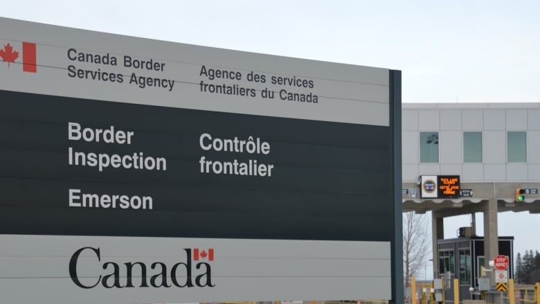 Image of border crossing with a sign in the foreground saying Border Inspection Emerson.