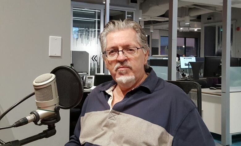 A bearded man sitting in a radio studio.