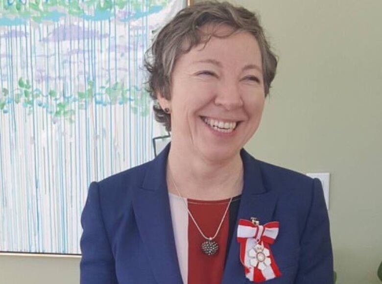 A woman with short hair smiles.